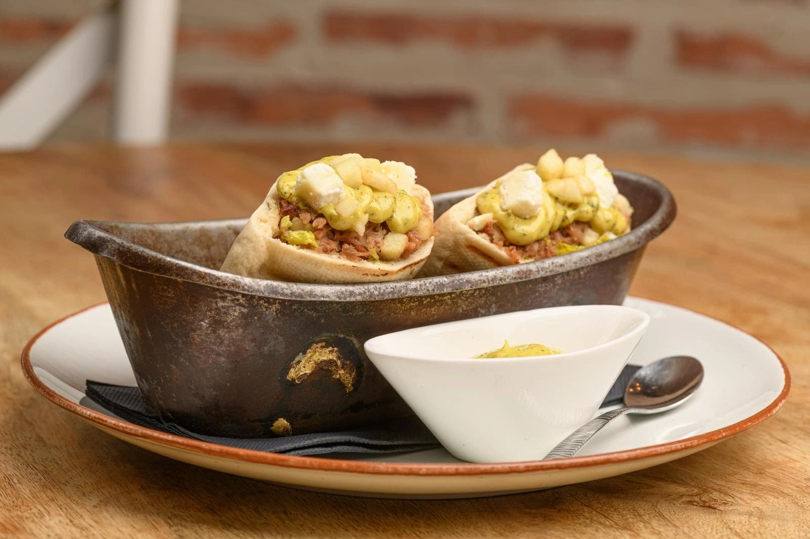 Bocados gastronómicos servidos en un recipiente metálico.